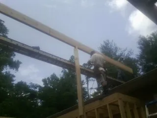 Carpenter setting a ridge beam over a new addition frame — Ice Dam Removal by Roofing Brothers in Eckley