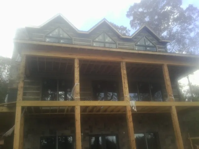 Dormers and porch framing on a large log home under construction — Roof Coating work by our crew in Eckley
