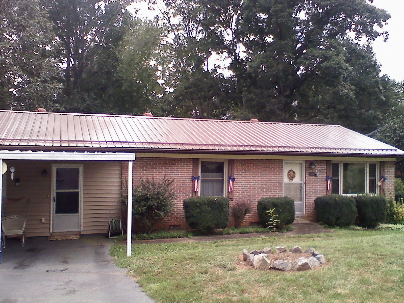 Bronze metal roof and carport on a brick ranch home — Roof Repair work by our crew in Eckley